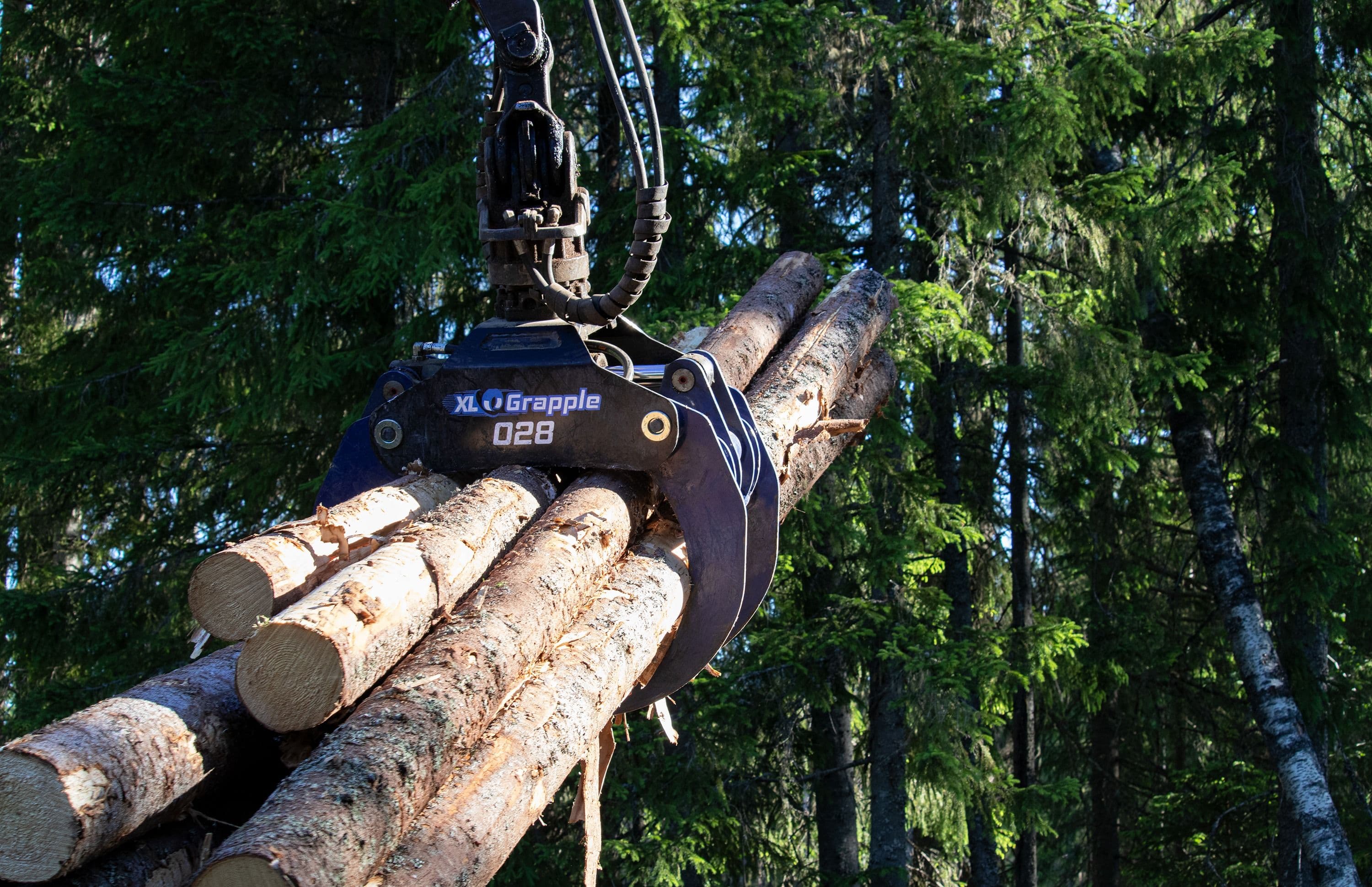 En XL Grapple-grip lyfter timmer i skogen